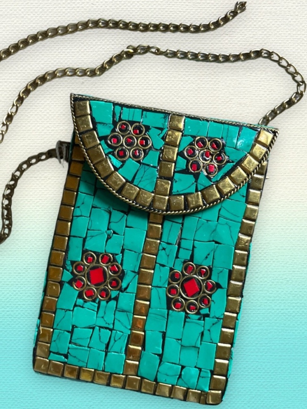 Antik Kraft metal mosaic turquoise clutch with chips of red and inlaid gold.